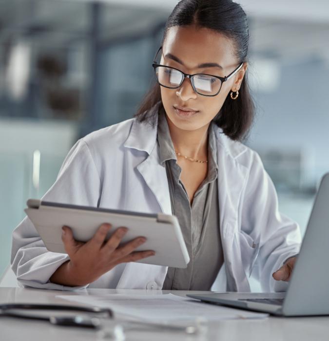 Female doctor using a digital tablet and computer at work